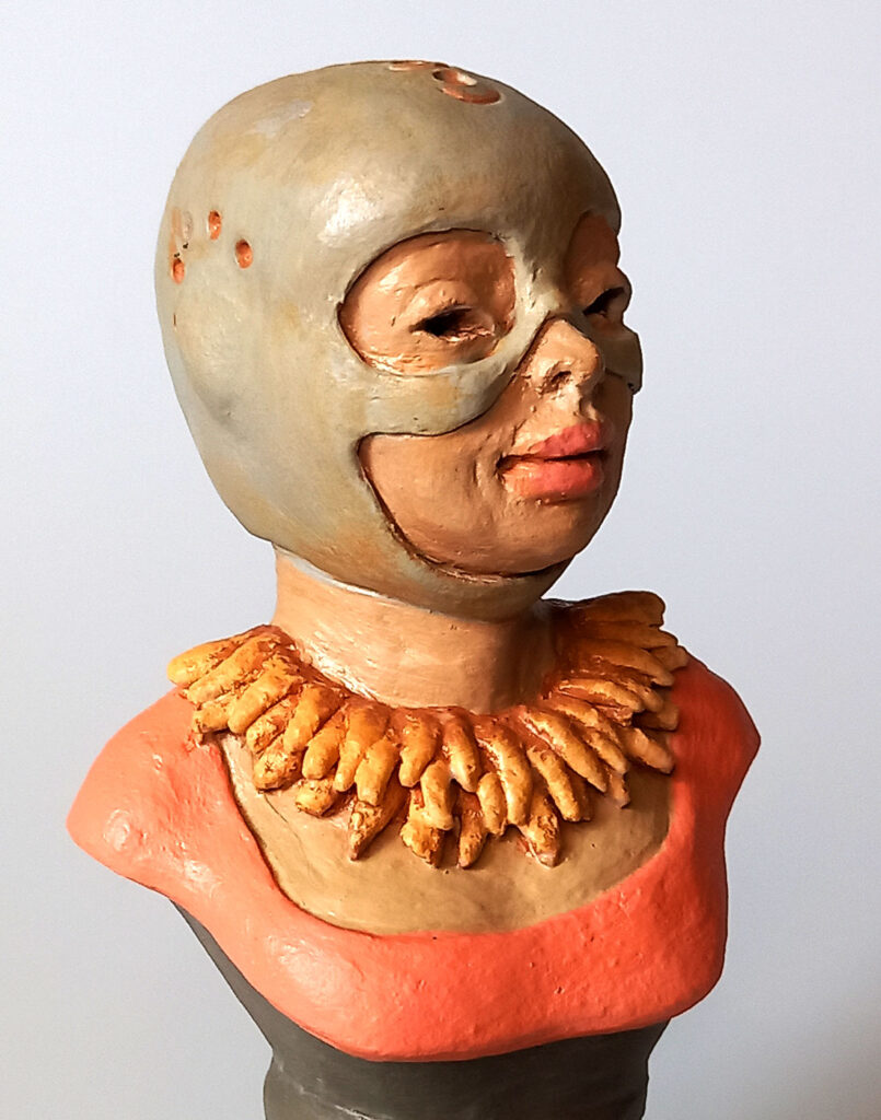 etalhe em close-up das feições e pintura da estatueta autoral em cerâmica policromada Lady Adah Aviadora