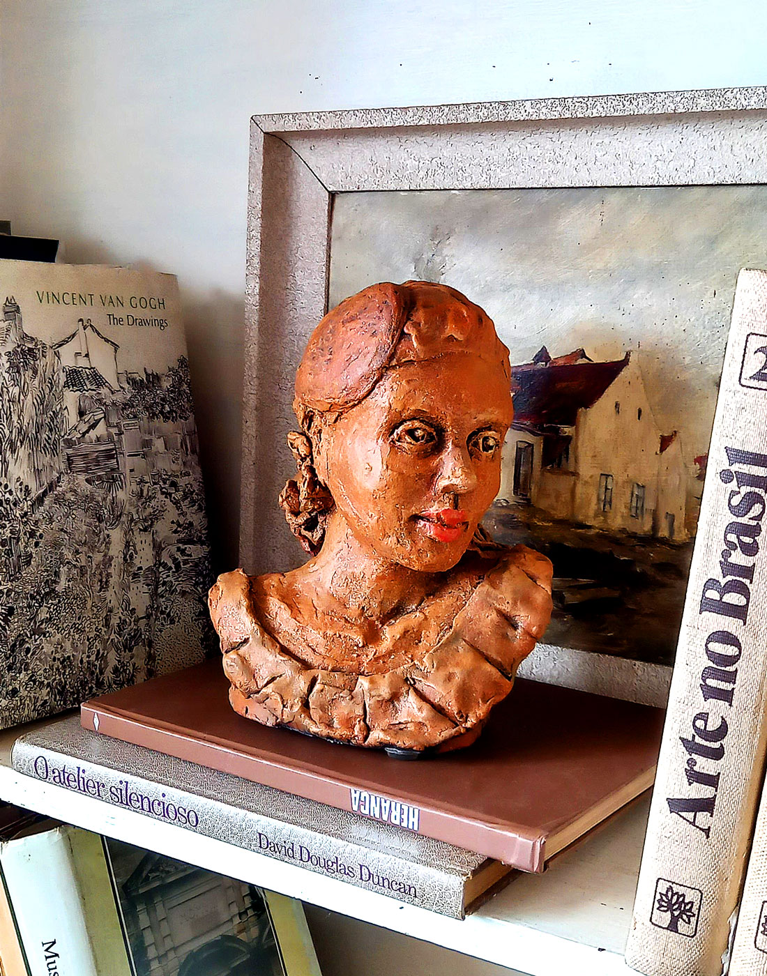 Escultura cerâmica Retrato de Cecília em ambiente decorado com livros