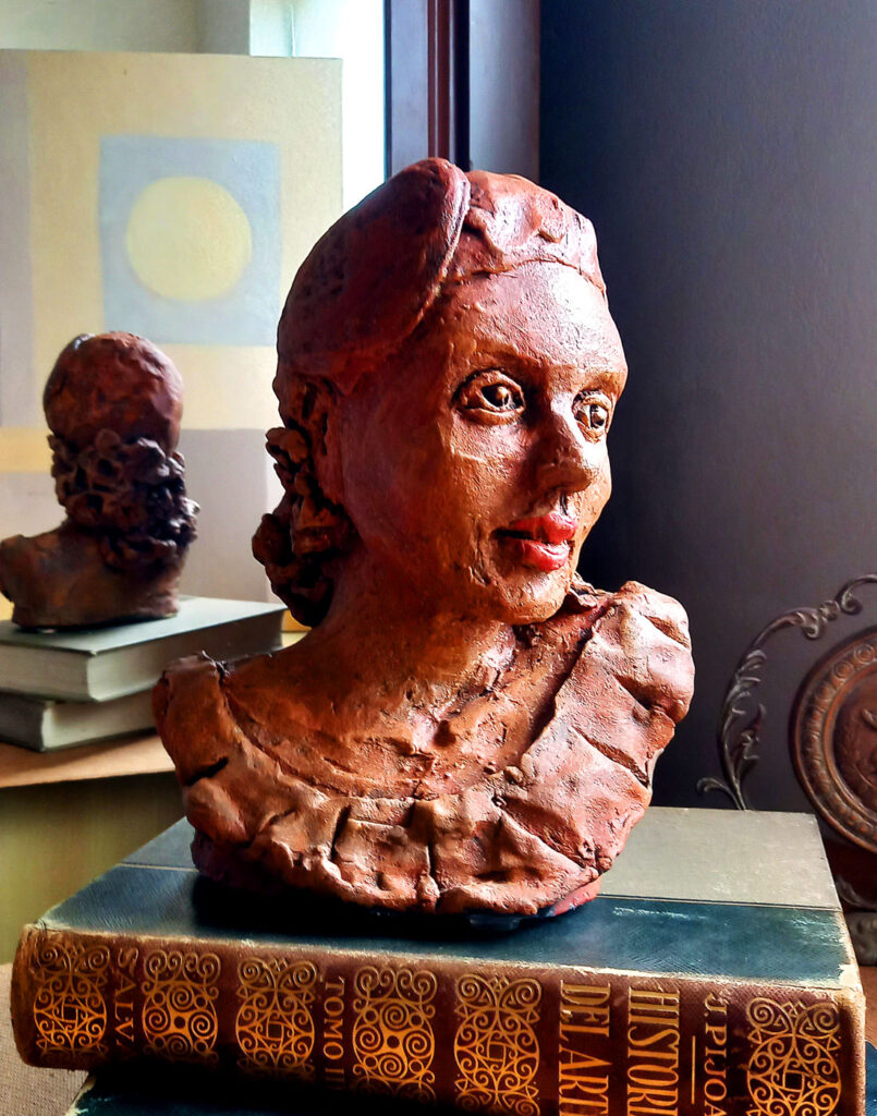 Escultura cerâmica Retrato de Cecília em ambiente decorado com espelho ao fundo