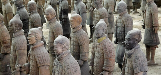 Estátuas de guerreiros de terracota com partes com pigmentos originais preservados em tons de vermelho, rosa e verde nas vestimentas.