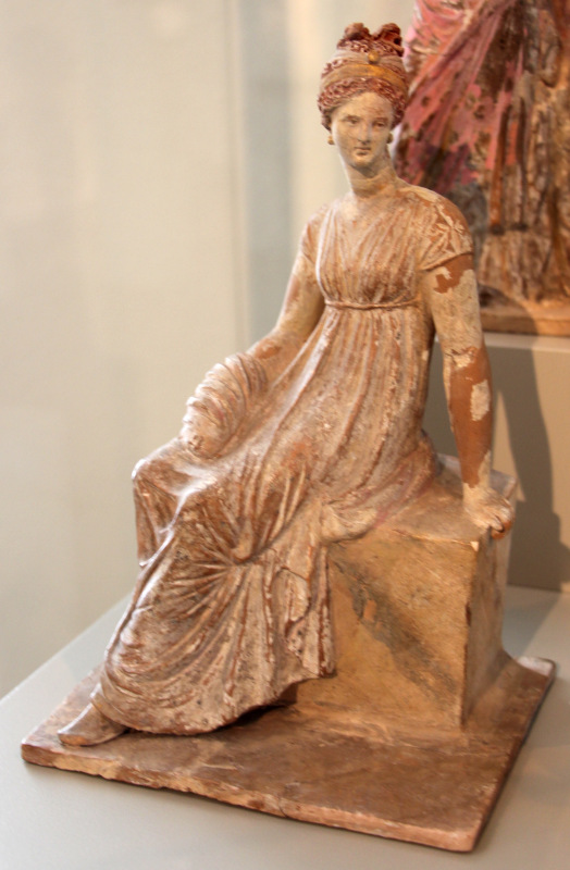 foto de uma estatueta de cerâmica de figura feminina elegante sentada vestindo roupas gregas