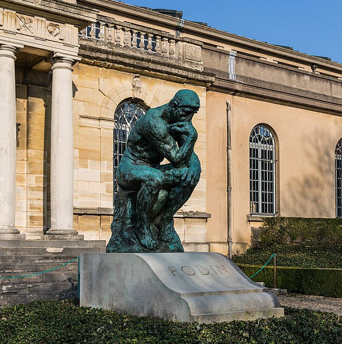 estátua em bronze sobre um túmulo em um jardim