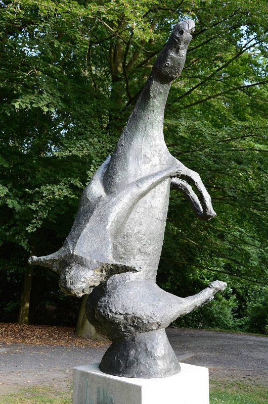 estátua em um parque feita em bronze cinza de um homem caindo de um cavalo