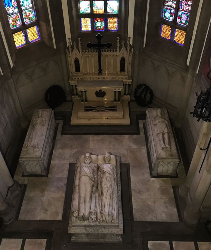 vista superior de uma igreja com vitrais e túmulos de mármore com tradição gótica com figuras de reis e rainhas deitados sobre os túmulos