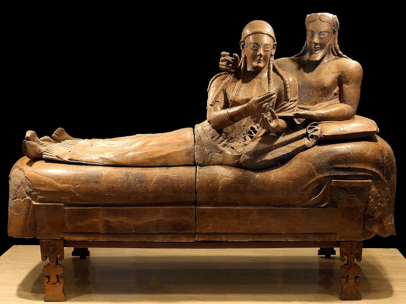 casal reclinado com expressão feliz em um cama de estilo etrusco, feito em terracota, exposto em um museu