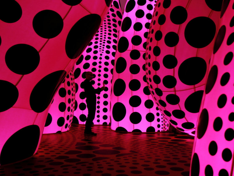 espaço artístico criado com estruturas translúcidas de cor rosa e pontos pretos
