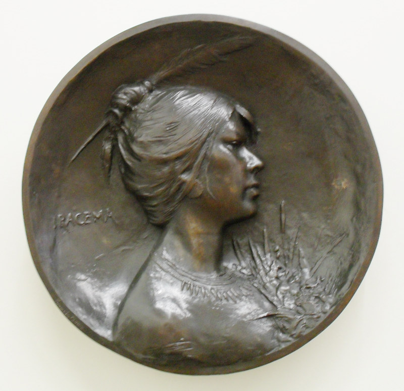 relevo em bronze de uma mulher de perfil com os cabelos recolhidos em um coque