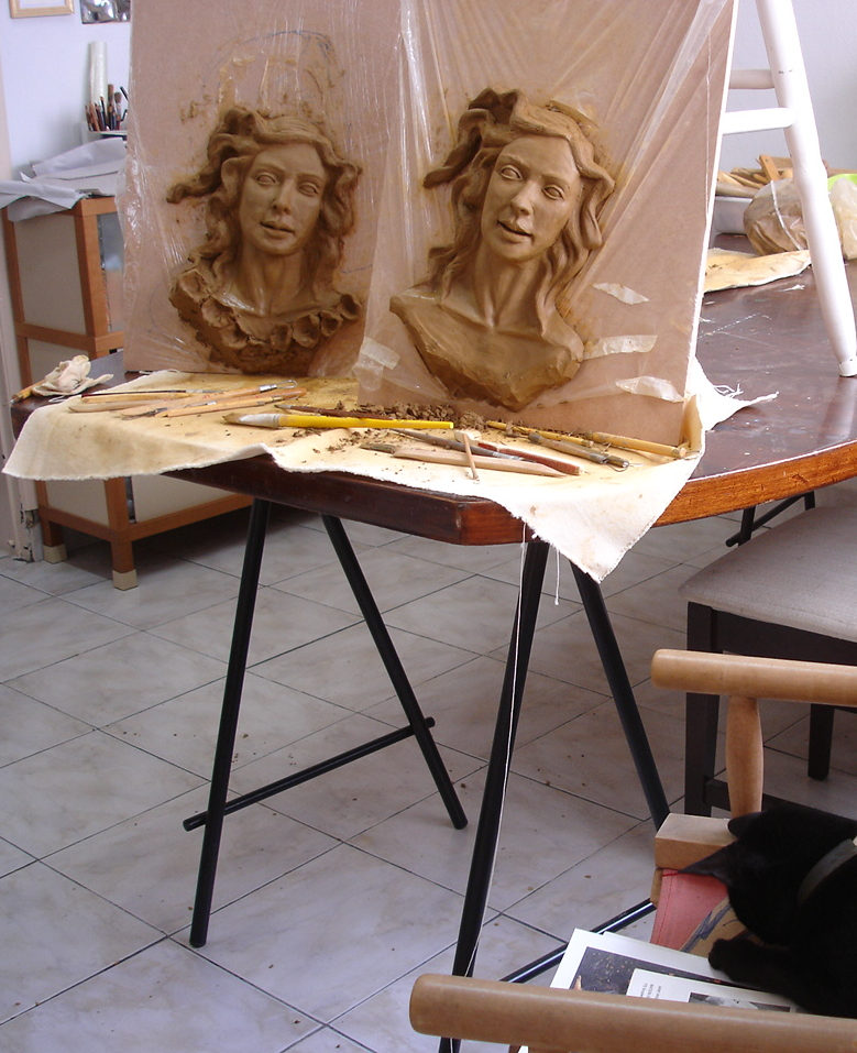 foto do interior de um ateliê de escultura com duas cabeças em argila de deusas da primavera sendo modeladas