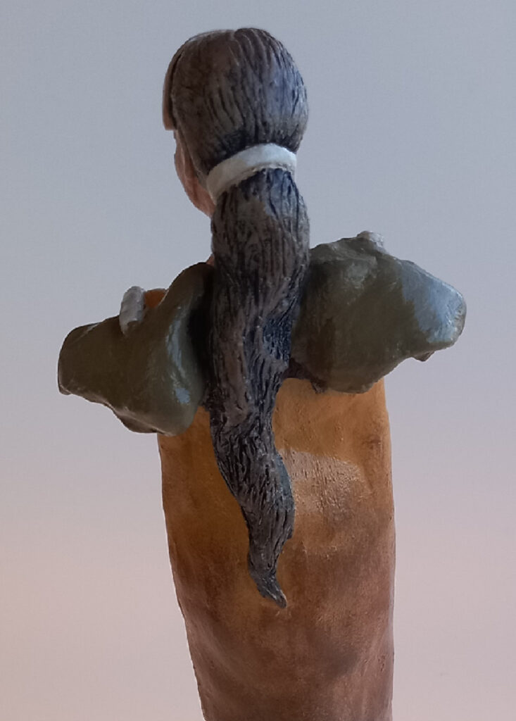 escultura de figura feminina com cabelos longos vista de costas